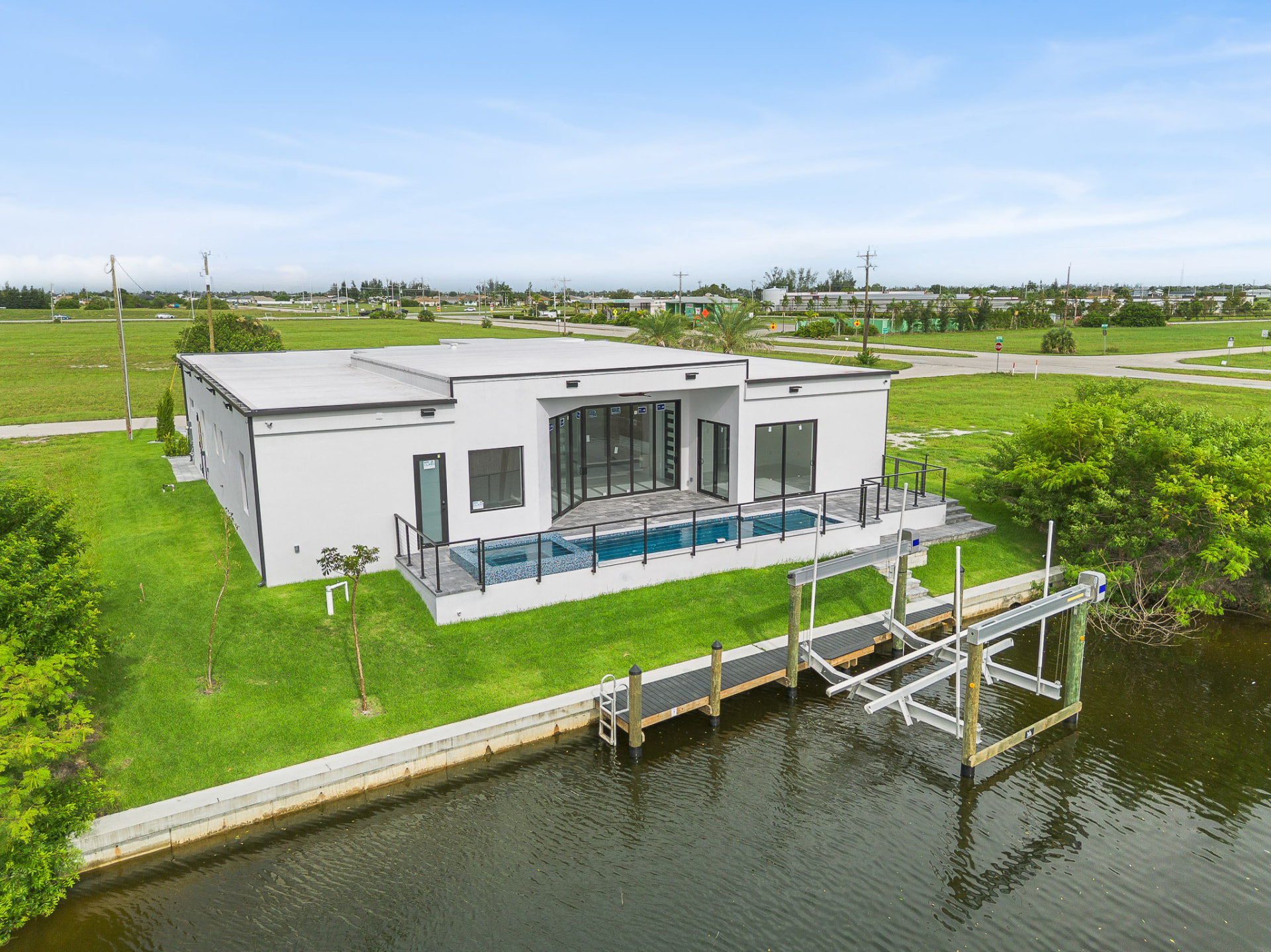 Waterfront home with pool and boat dock during the day