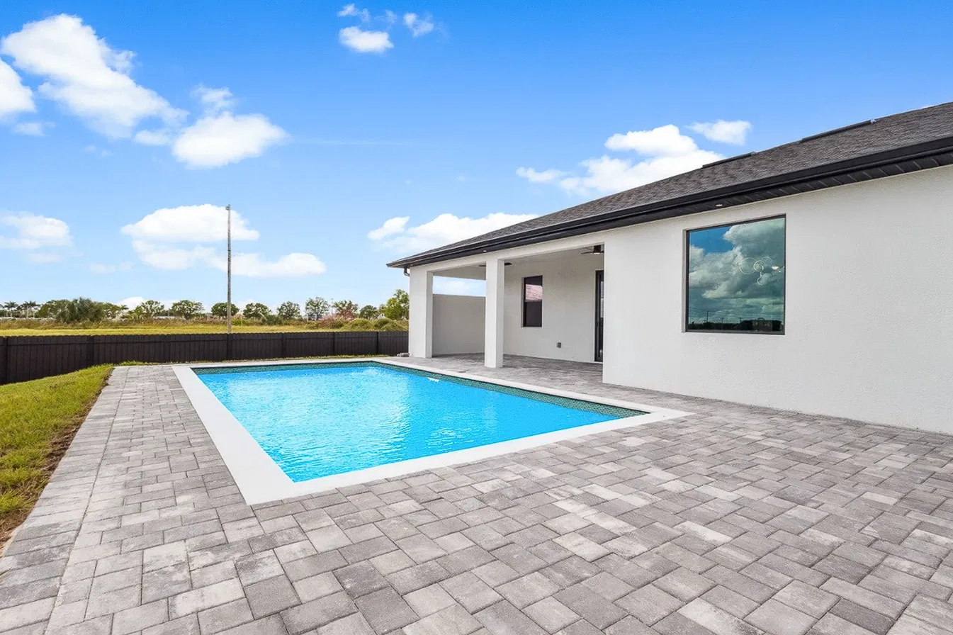 Same backyard after virtual pool enhancement with crystal-clear blue water